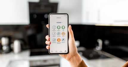 Woman using her smartphone in her kitchen at home-jpg